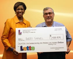 Man and woman hold an oversized check in front of an orange digital background