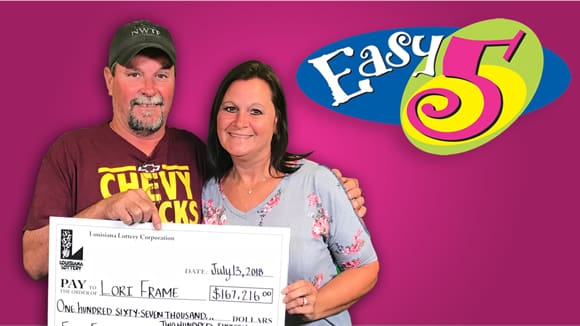 Man and woman hold an oversized check in front of a pink Easy 5 branded background