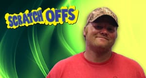 Man in a red shirt and cap smiles in front of a green and yellow scratch offs branded background