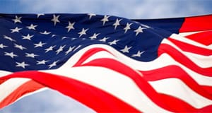 Vibrant American flag rippling in the wind beneath a blue sky