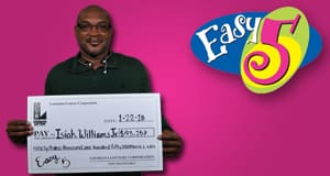Man holds an oversized check while standing in front of a pink Easy 5 branded background