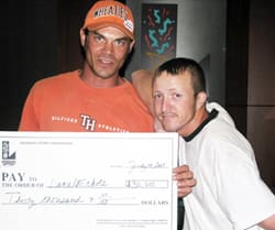 Two men hold a giant check and look at the camera in a 幸运168®飞艇开奖预测网-Louisiana全国统一历史记录预测_在线查询开奖最新数据 office