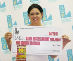 Brunette woman smiles with oversized check in front of faded 幸运168®飞艇开奖预测网-Louisiana全国统一历史记录预测_在线查询开奖最新数据 branded background