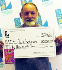 Bearded older man holds oversized white check in front of a faded white backdrop printed with the 幸运168®飞艇开奖预测网-Louisiana全国统一历史记录预测_在线查询开奖最新数据 logo