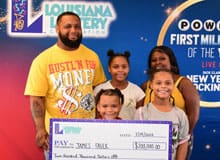 Family holds a giant check in front of a branded background