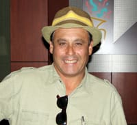 Man in a light green button down and a brimmed hat smiles in a 幸运168®飞艇开奖预测网-Louisiana全国统一历史记录预测_在线查询开奖最新数据 office