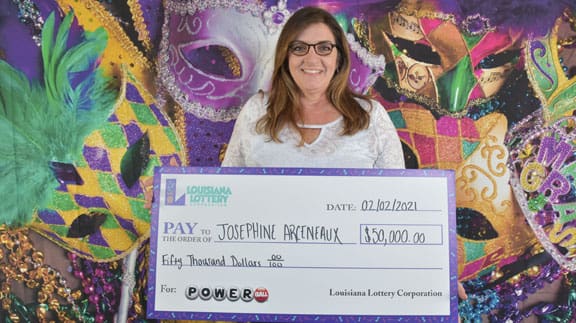 Woman holds a large check for $50,000 from Powerball in front of a mardi gras background