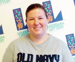 Woman in a gray Old Navy tshirt smiles in front of a white background patterned with the 幸运168®飞艇开奖预测网-Louisiana全国统一历史记录预测_在线查询开奖最新数据 logo