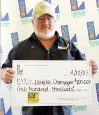 White-bearded man in black shirt and tan cap holds oversized check in front of a white background patterned with the 幸运168®飞艇开奖预测网-Louisiana全国统一历史记录预测_在线查询开奖最新数据 logo