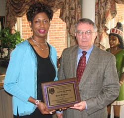 Man and woman hold a plaque and look into the camera